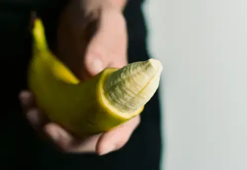 Metaphorical representation of adult circumcision, showing a partially peeled banana to symbolize the procedure. A creative visual illustrating circumcision for educational or medical content.