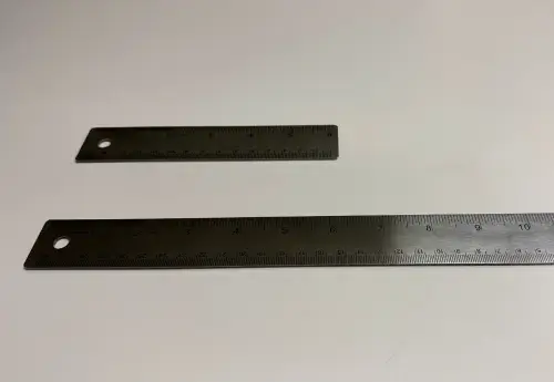 a 6 inch ruler and a 12 inch ruler lay on a white counter parallel to each other illustrating penis enlargement before and after the procedure