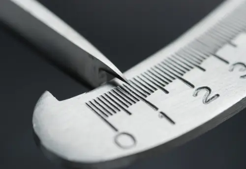 Close-up of precision caliper on a metal ruler, representing the importance of accuracy when measuring your penis size for enhancement planning.
