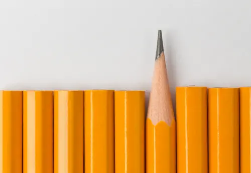 One sharpened pencil standing out among unsharpened pencils, symbolizing differences in penis size and the concept of average penis length and girth.